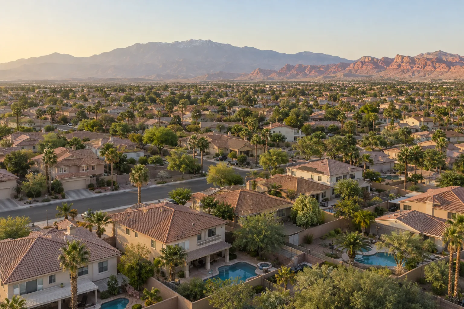 Aerial view of a Las Vegas suburban neighborhood with tile roofs, pools and the Spring Mountains in the distance